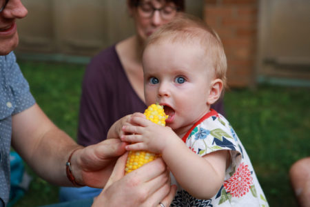Baby eating corn